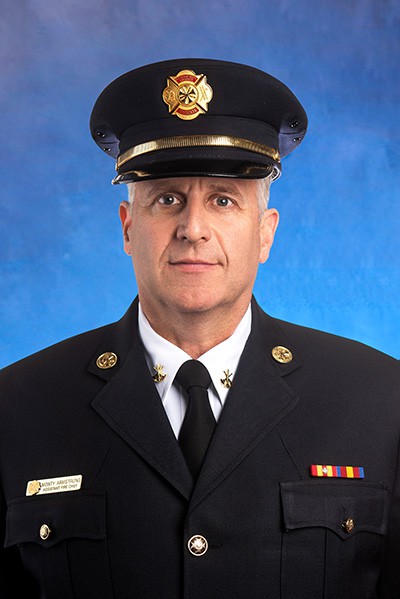 A headshot of assistant fire chief Monty Armstrong in a formal blue uniform.