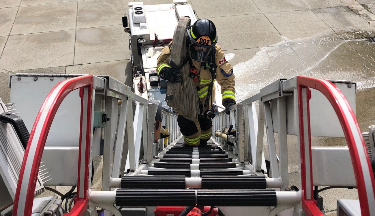 A DNVFRS members ascends a ladder.