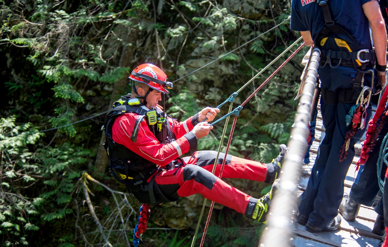 Photo of a DNVFRS firefighter preparing to rappel.