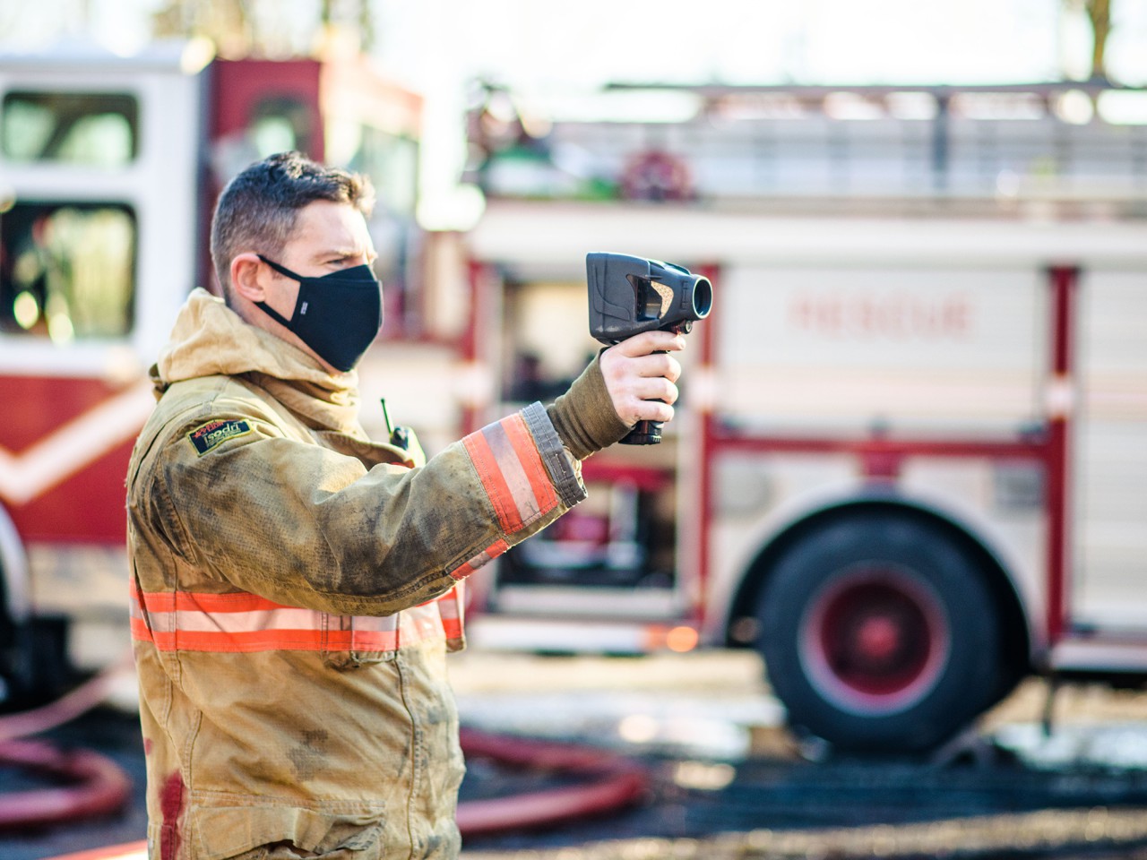 A firefighter holds up a thermal imaging device.