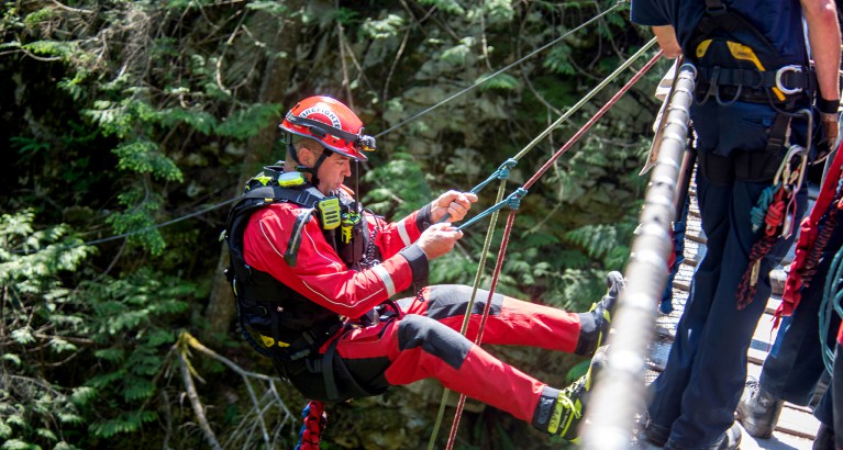 Photo of a DNVFRS firefighter preparing to rappel.