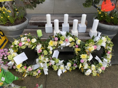 Flowers and written tributes at the Lynn Valley Village memorial. 