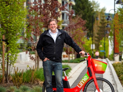 Mayor Mike Little stands beside an electric bike.