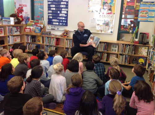A member of the DNV fire department reading to a group of children