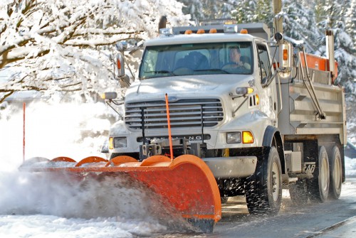 A snowplow clearing a District street